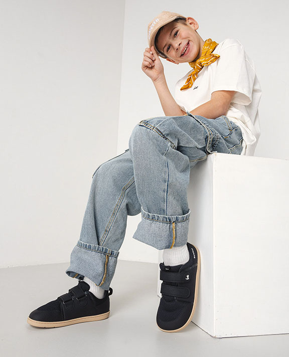 Garçon assis avec des chaussures barefoot Be Lenka Junior de la collection printemps-été, pointures 35–38